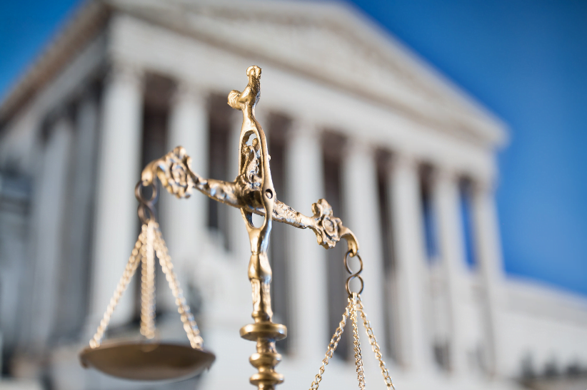 An image of the law courts with the scales of justice swinging in the foreground.