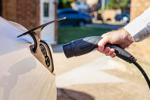 A sleek and modern home EV charger mounted on a brick wall, showcasing the seamless integration of sustainable technology in an architectural design