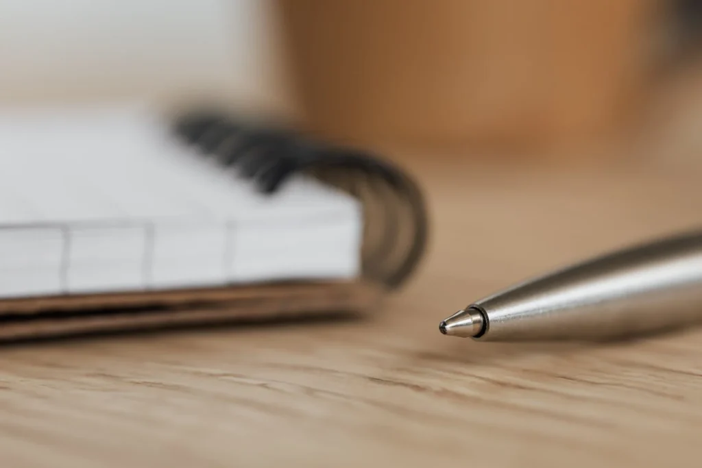 Image of a pen and paper, symbolizing the delivery of policies about the National Planning Policy Framework (NPPF) and its role in promoting sustainable architecture in the UK by encouraging the use of low-carbon materials, promoting sustainable transport, and incorporating green infrastructure.