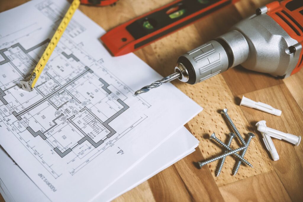 Architectural plans with a drill and ruler, ready to be reviewed for Retrospective Planning Permission by the local council