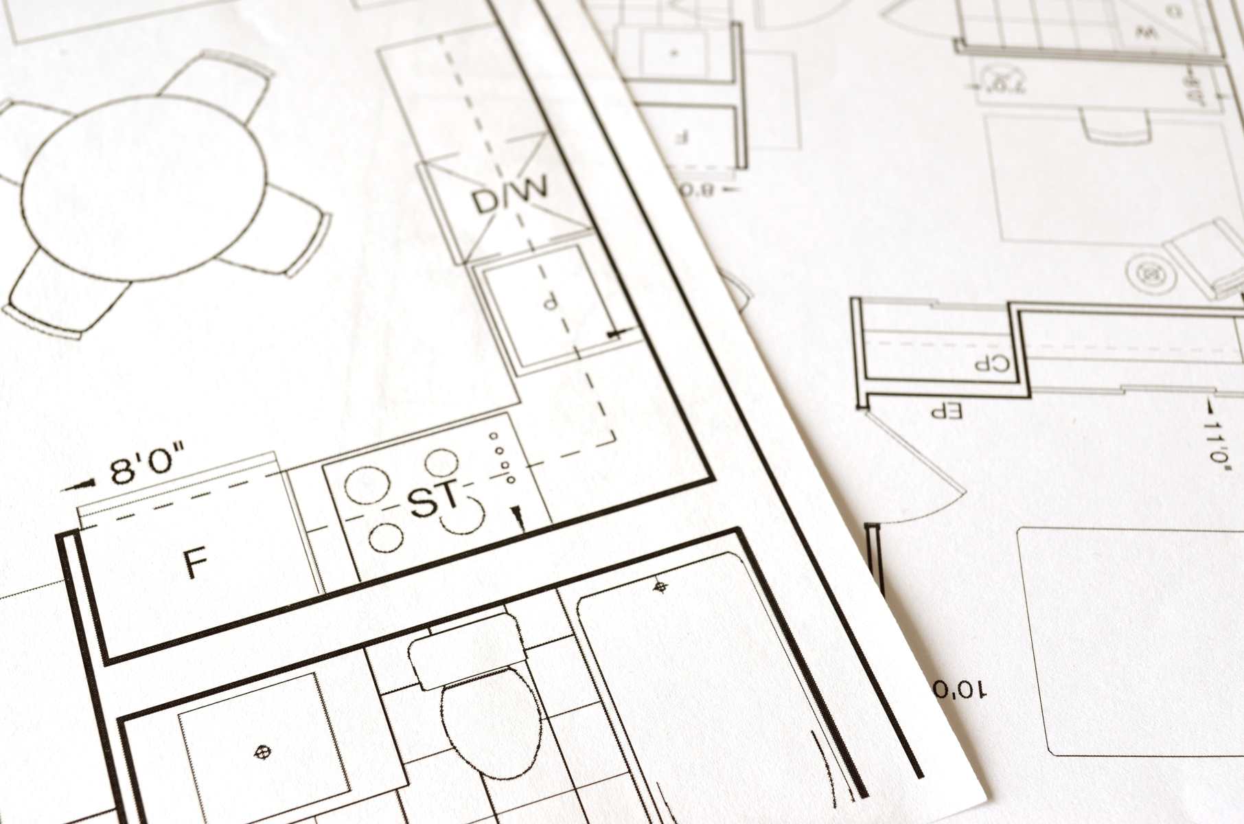 Image of a person holding a blueprint and standing in front of a construction site, representing the concept of building works and construction in the UK. The text "Understanding Permitted Development | A Guide to Building Without Planning Permission in the UK" is overlaid on the image