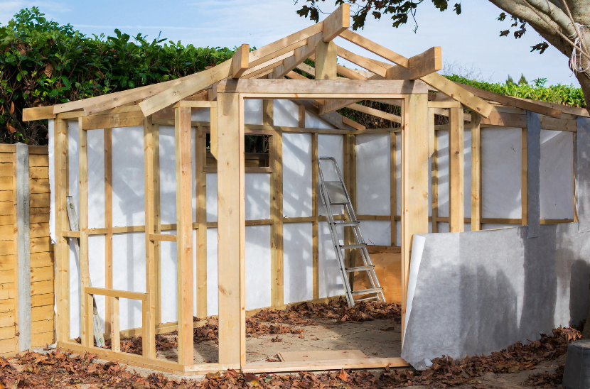 An elegant, modern garden building featuring large windows, blending seamlessly with the surrounding landscape, perfect for a home office or leisure space.
