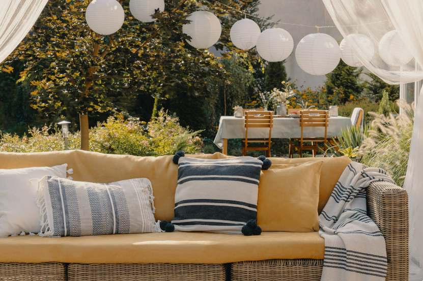 A beautifully designed outdoor living room featuring comfortable seating, a fire pit, and lush surrounding greenery, exemplifying the possibilities for outdoor living spaces.