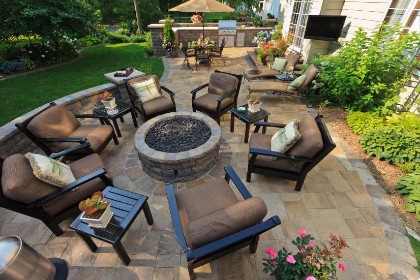A beautifully designed outdoor living space merging seamlessly with an elegant indoor setting, showcasing modern furniture, greenery, and architectural finesse by Shear Architectural Design.